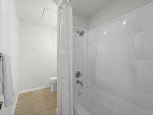 Bathroom with shower / tub combo with curtain and wood tiled floors