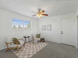 Sitting room featuring light carpet and a ceiling fan