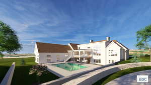Rear view of house with a patio, a lawn, a chimney, and a balcony