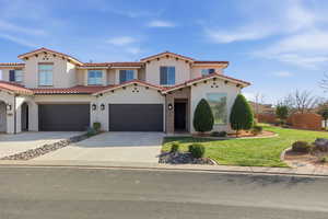 Mediterranean / spanish-style home with concrete driveway, a front yard, stucco siding, and a tile roof