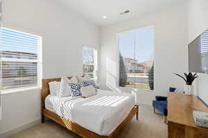 Bedroom featuring light colored carpet and baseboards