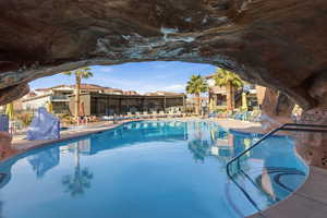 Community pool with a patio area and a grill