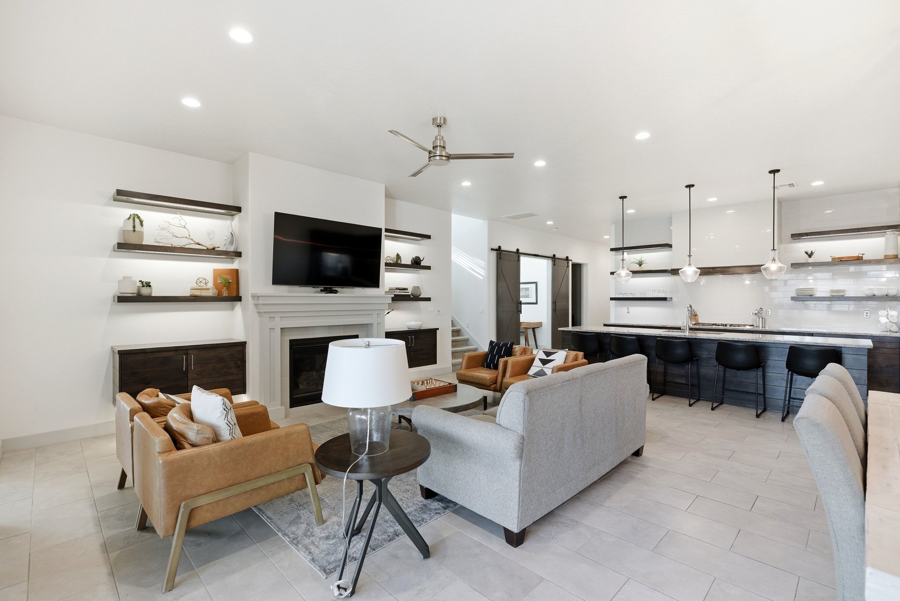 Living area featuring a barn door, a glass covered fireplace, ceiling fan, and recessed lighting