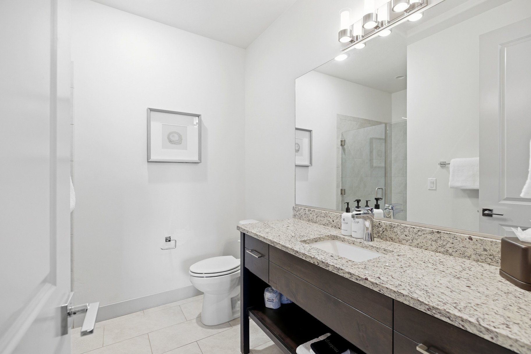 Bathroom featuring a stall shower, vanity, and light tile patterned floors