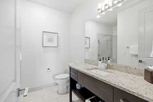 Bathroom featuring a stall shower, vanity, and light tile patterned floors