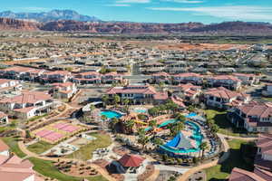 Aerial perspective of suburban area featuring a mountain backdrop and a pool area