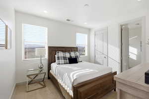 Bedroom with light carpet and a closet
