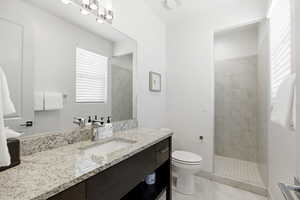 Full bath featuring vanity, walk in shower, and light tile patterned floors