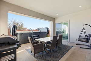 View of patio / terrace with outdoor dining area, a grill, and a hot tub