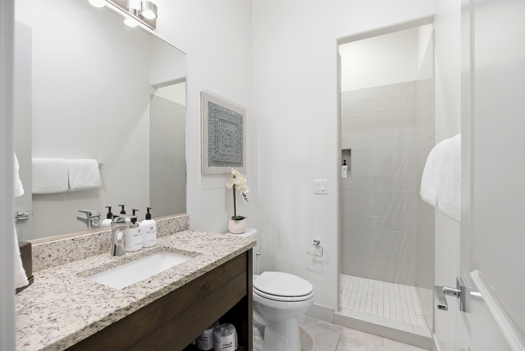 Bathroom with vanity, a walk in shower, and light tile patterned floors