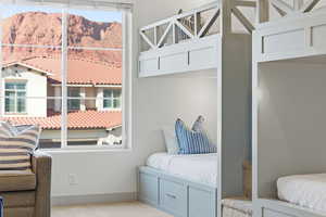 Carpeted bedroom with a mountain view and multiple windows