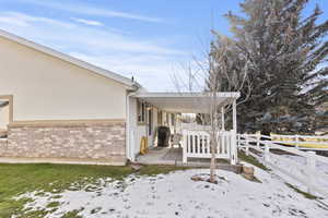 View of snowy exterior featuring brick siding and stucco siding