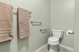 Half bathroom featuring baseboards and toilet