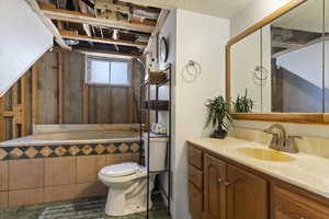 Bathroom featuring vanity and tiled tub