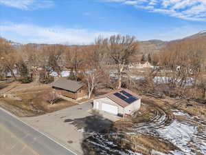 Snowy aerial view with a mountain view and a residential view