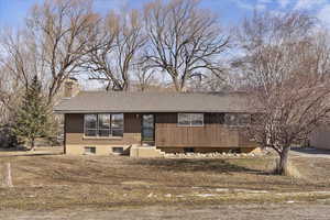 Ranch-style home featuring a chimney and a shingled roof