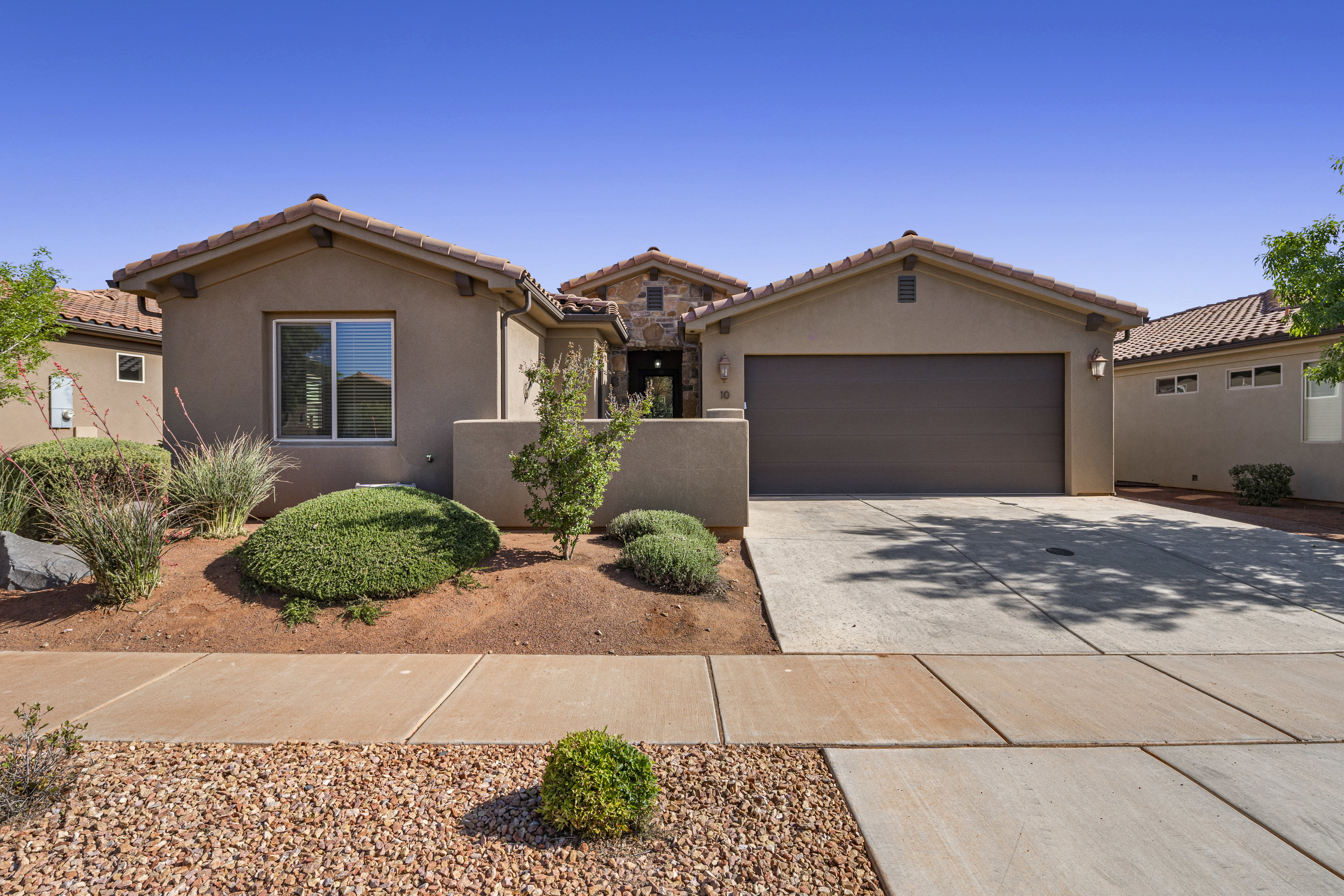 Mediterranean / spanish home featuring driveway, stucco siding, a garage, and a tile roof
