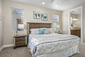 PrimaryBedroom with light carpet, a ceiling fan, connected bathroom, and recessed lighting