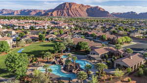 Aerial view of residential area featuring a mountainous background and a pool area