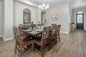 Dining space featuring wood finish floors and a chandelier