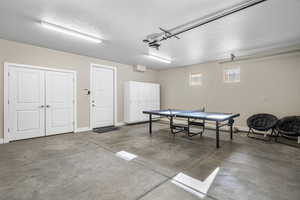 Game room featuring concrete flooring, a garage, and a textured ceiling