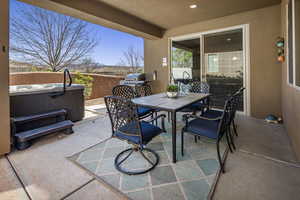 View of patio / terrace with outdoor dining space, a hot tub, and a grill