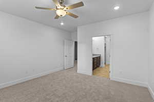 Unfurnished bedroom with a ceiling fan, recessed lighting, light carpet, and connected bathroom