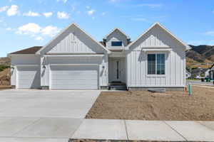View of front facade with concrete driveway, an attached garage, and board and batten siding