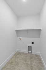 Laundry area featuring hookup for a washing machine, light tile patterned floors, and electric dryer hookup