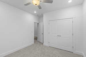 Unfurnished bedroom with light colored carpet, ceiling fan, a closet, and recessed lighting