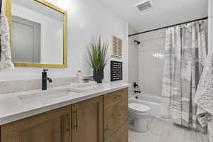 Full bathroom with shower / tub combo with curtain and vanity