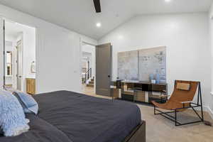 Carpeted bedroom featuring lofted ceiling, recessed lighting, ceiling fan, and ensuite bath