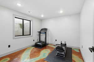 Bedroom used as an exercise area with recessed lighting and finished concrete floors