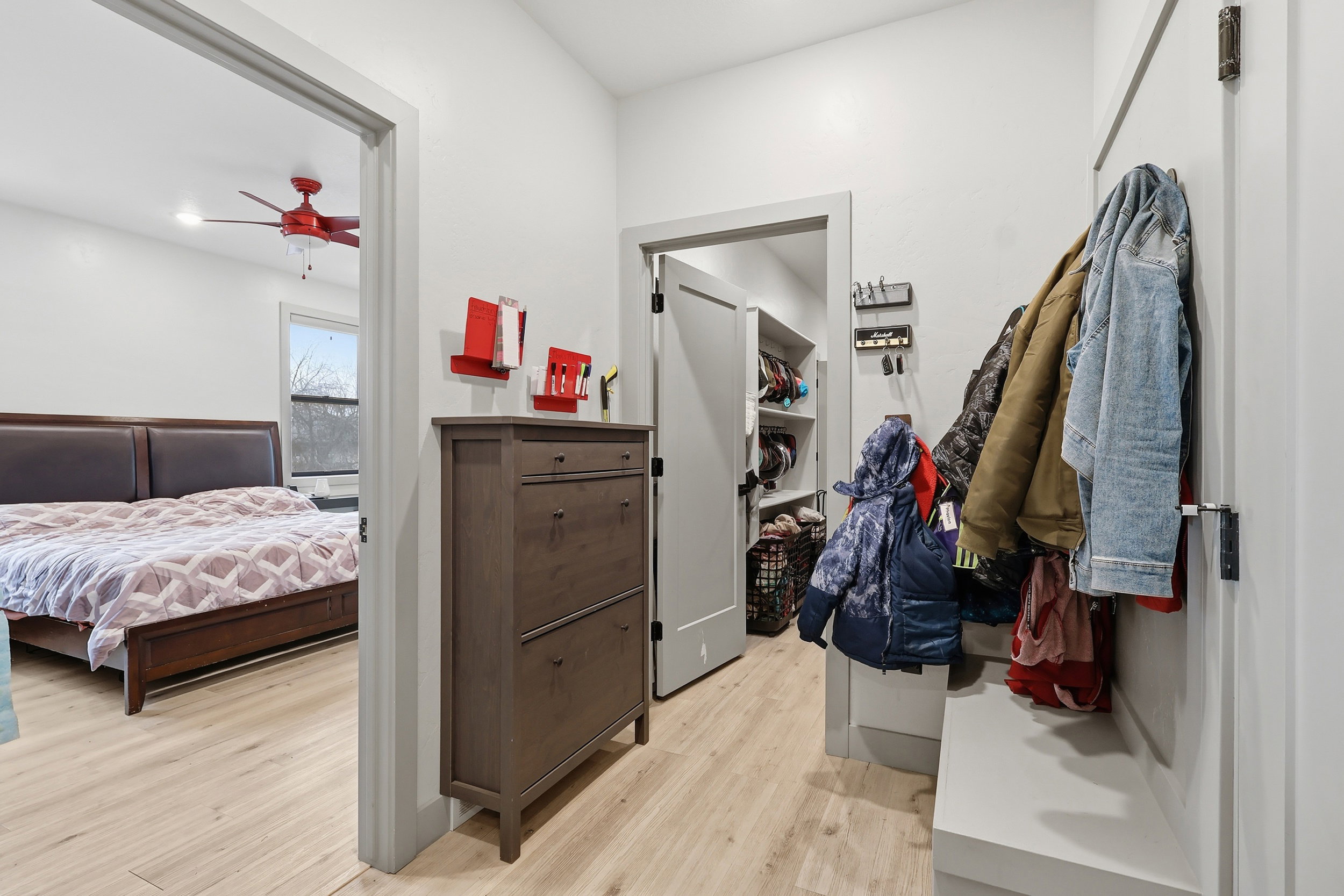 Drop zone with doggy door to garage light wood-type flooring and ceiling fan
