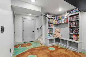 Family Room game nook featuring finished concrete floors and built in bookshelves.