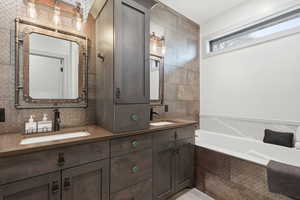 Master bathroom featuring double vanity, a garden tub, and backsplash
