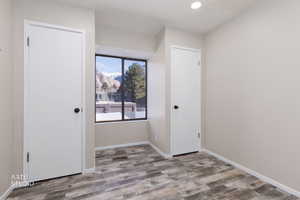 Unfurnished room with a mountain view, light wood-type flooring, and recessed lighting