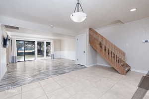Unfurnished living room with recessed lighting and light tile patterned floors