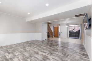Unfurnished living room with wainscoting, light wood-style floors, and recessed lighting