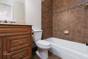 Full bathroom featuring vanity, shower / bath combination, and a textured wall