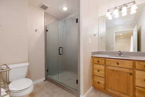 Full bath with a shower stall, vanity, and light tile patterned floors