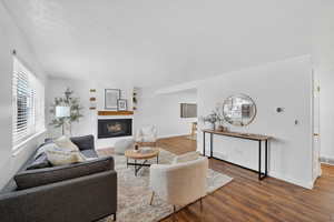 Living room with a warm lit fireplace,  LVP wood flooring throughou