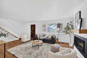 Living room featuring wood finished floors and a lit fireplace