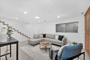 Basement Family Room featuring light carpet and stairway
