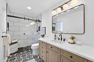 Bathroom with vanity, a shower stall, a textured ceiling, and dark tile patterned floors