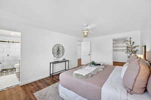 Primary Bedroom with a walk-in closet, wood finished floors, ceiling fan, and ensuite bathroom