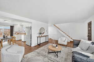 Living room with stairway and wood finished floors