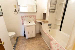 Bathroom featuring vanity and shower / bath combination with curtain
