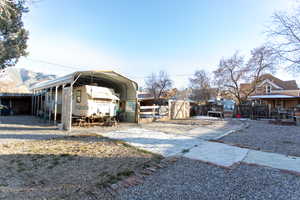 View of outdoor structure with a carport and driveway