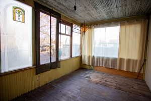 Unfurnished sunroom featuring hardwood / wood-style flooring